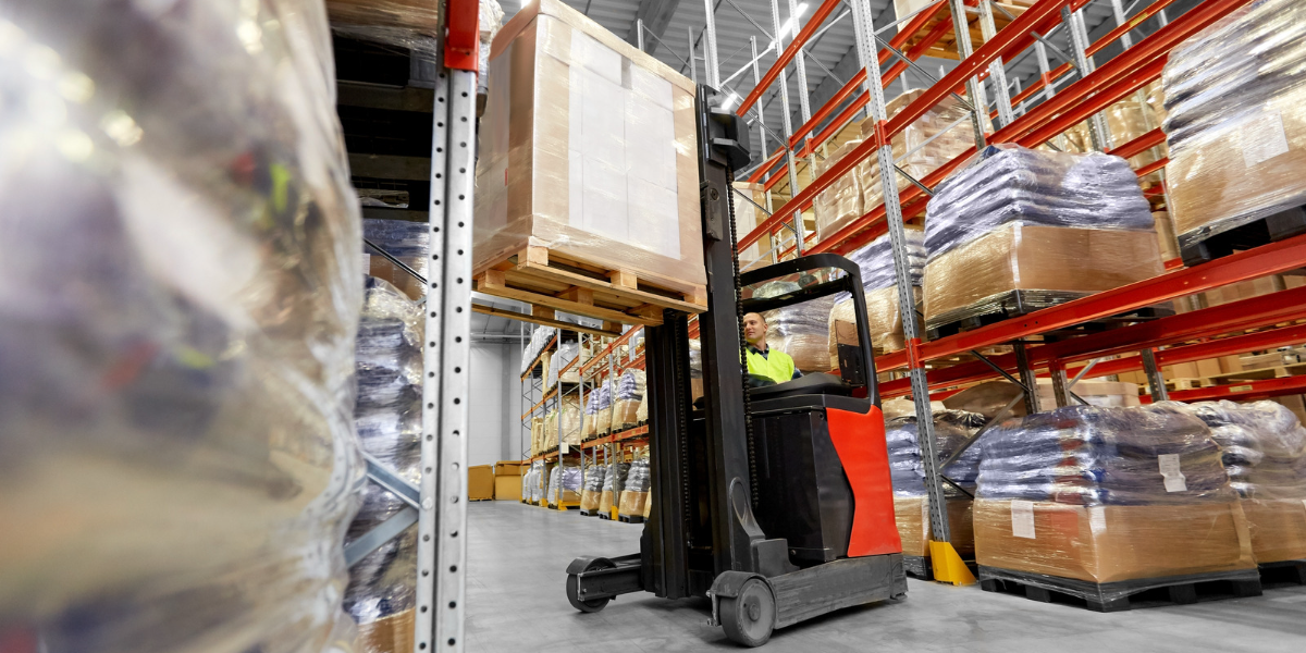 A forklift truck lifting a pallet onto a racking system